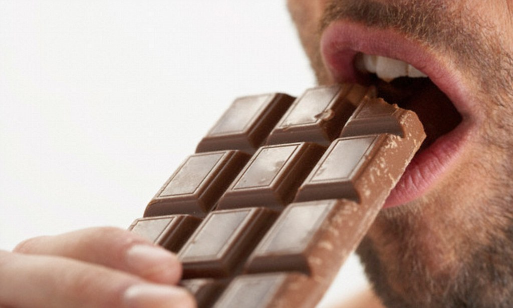 Young Man eating dark chocolate for prostate health