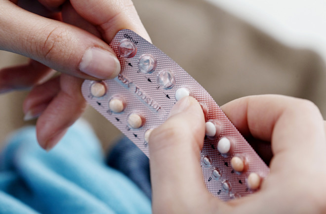 Woman holding a contraceptive pill