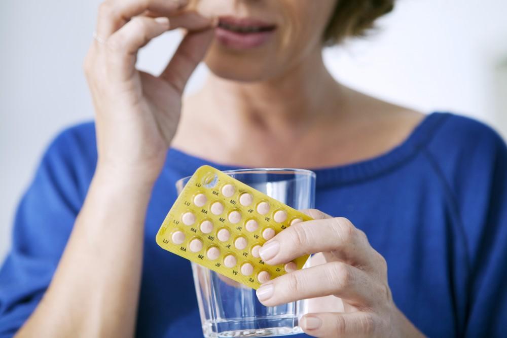 woman taking birth control contraceptives