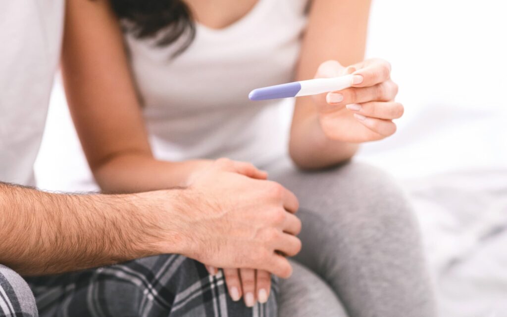 man and woman checking pregnancy test