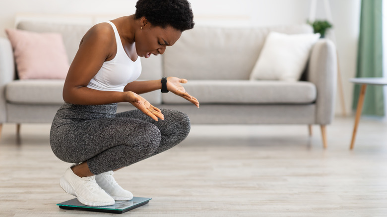 woman checking her weight after taking birth control pills