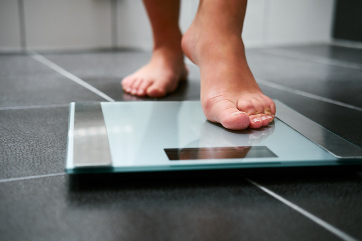 lady checking her weight after taking birth control pills