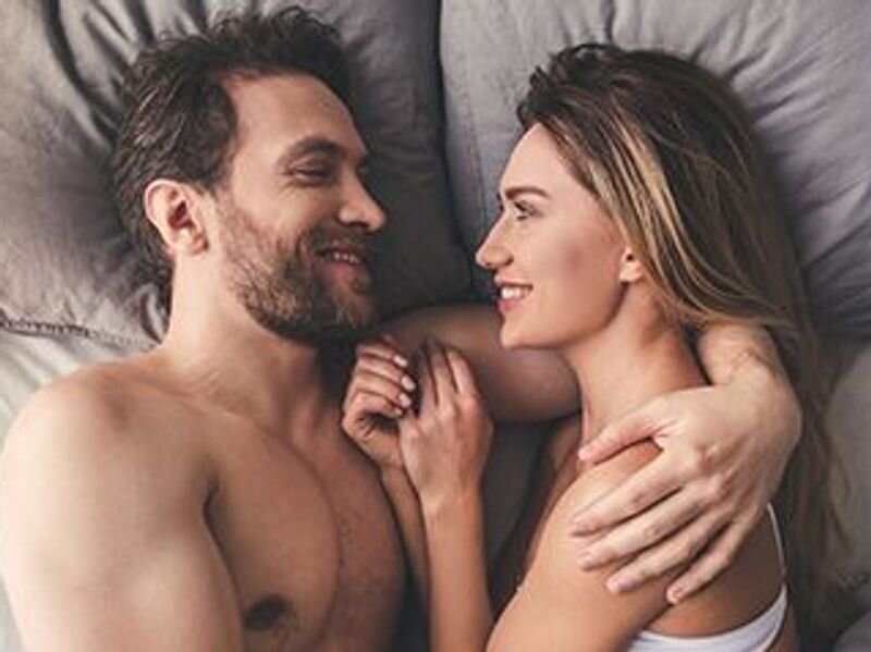 Couples lying on their bed happily