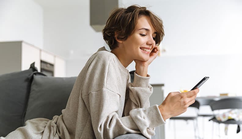 young lady looking at her phone happily