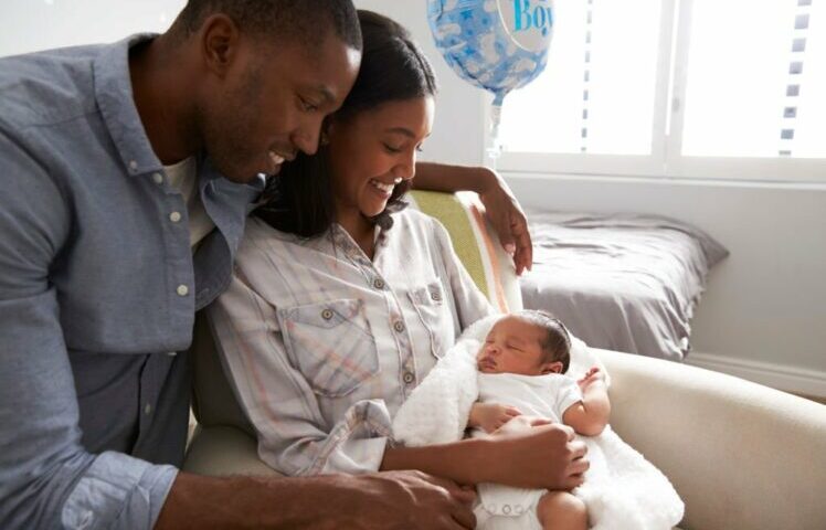 couples happily staring at their baby