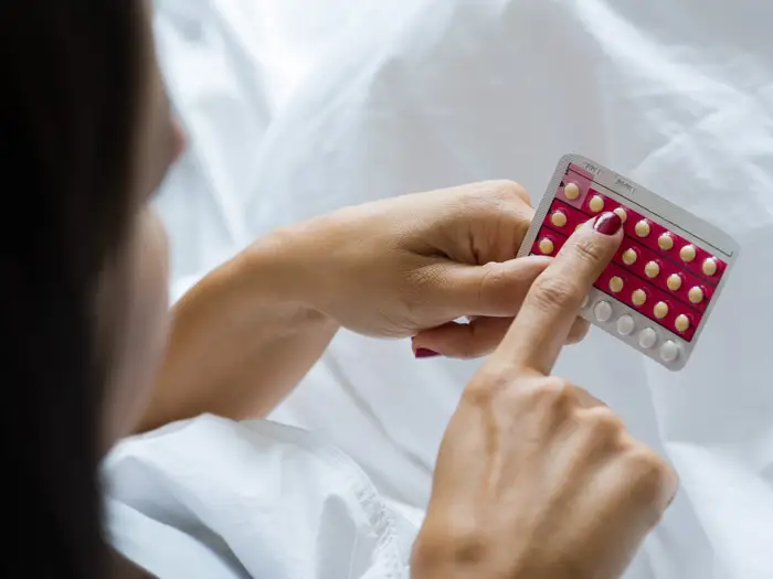 woman holding birth control pills