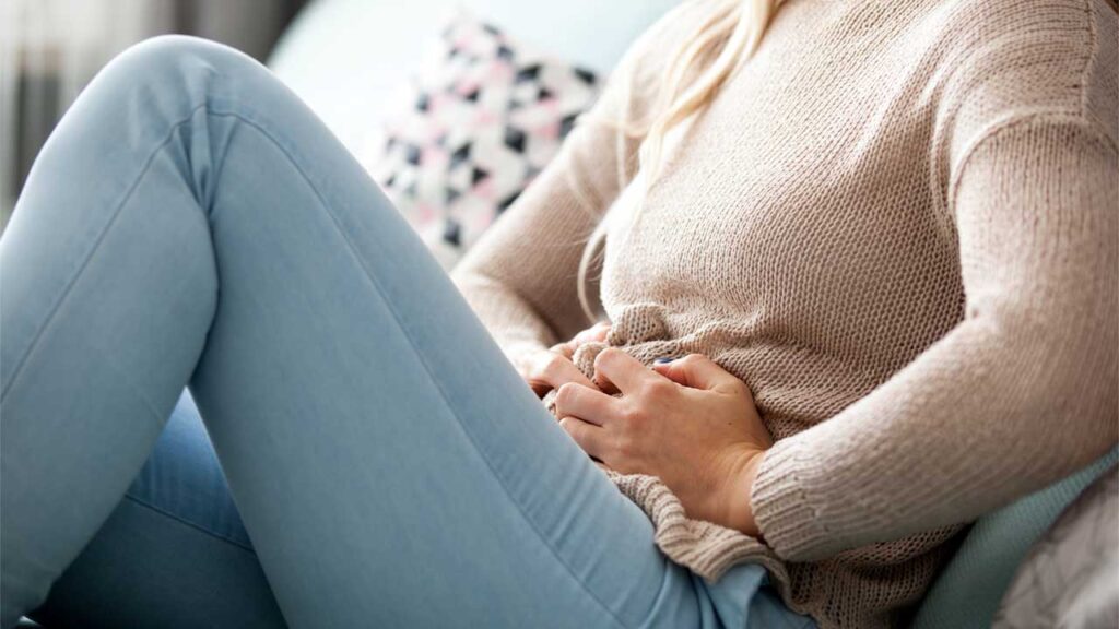 woman clenching her stomach in pain