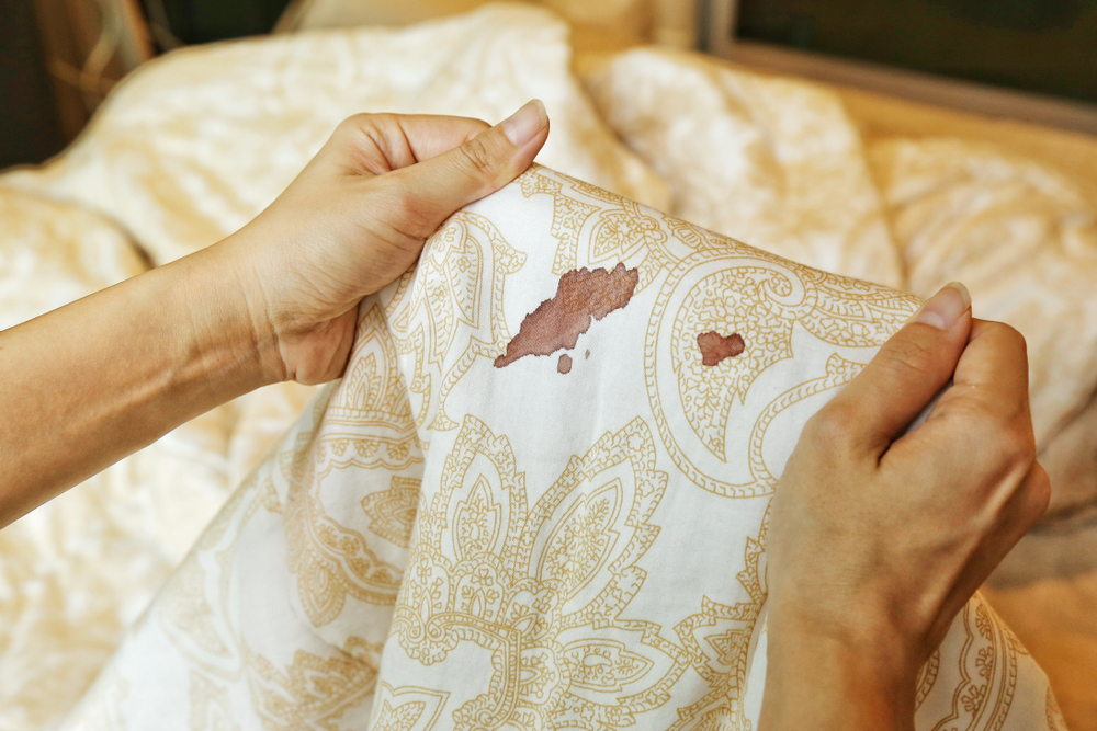 woman holding up a cloth stained with blood