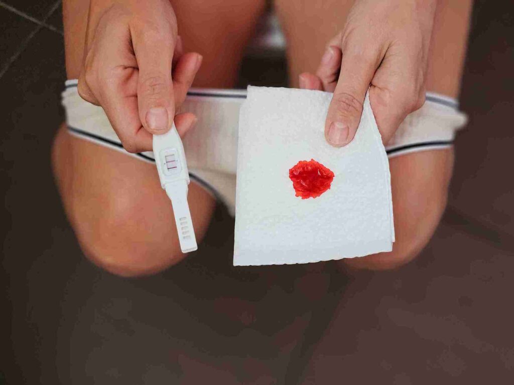 woman holding a test strip and stained cloth