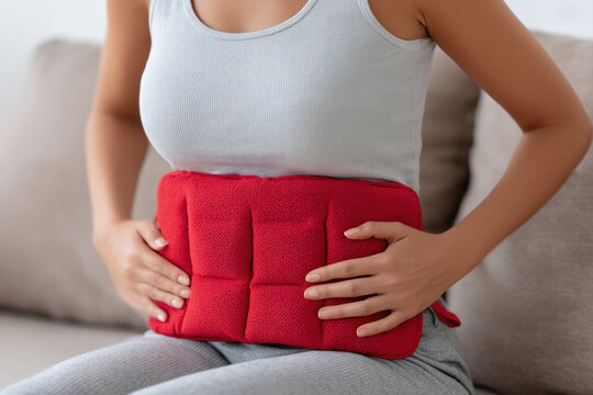 applying heat pad on abdomen